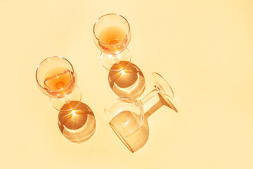 Wine glasses with contrasting shadows on a peach background