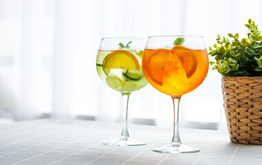 Close-up colorful aperol spritz drink and  gin tonic cocktails in wine glasses on the table at...