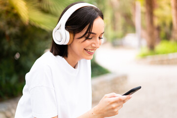 Young woman listening music at outdoors