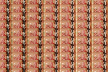 50 Canadian dollars bills printed in money production conveyor. Collage of many bills. Concept of...