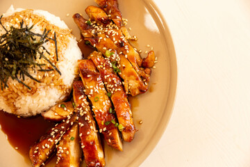Toriyaki chicken rice on a plate, served with food photos, top view