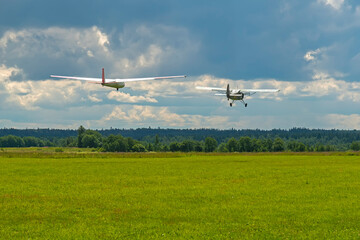 Plane towing a glider during takeoff from airfield