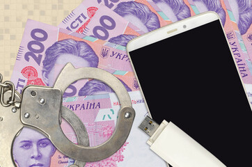 200 Ukrainian hryvnias bills and smartphone with police handcuffs. Concept of hackers phishing...