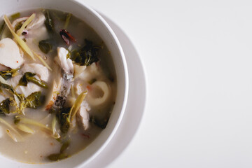Thai food Tom Yam Seafood spicy white soup served in white bowl.