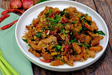 Stir fry pork with lemongrass and chilli on wooden table. Authentic Thai food.