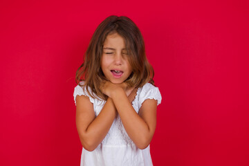 Little caucasian girl with blue eyes wearing white dress standing over isolated red background shouting suffocate because painful strangle. Health problem. Asphyxiate and suicide concept.