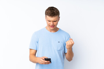 Young handsome man over isolated white background surprised and sending a message