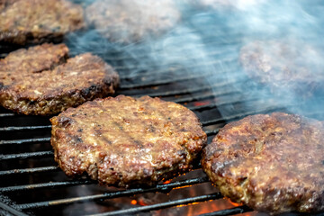 Juicy meat steaks cooked over charcoal on a wire rack. Meat cooked on a fire in the open air. Close-up.