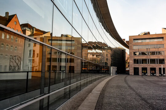 Houses reflections in glass wall of Neues Museum State museum for art and design in Nuremberg, Bavaria, Germany.