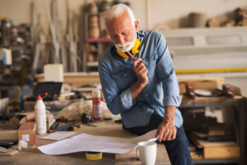 Engineer looking at the blueprint and thinking