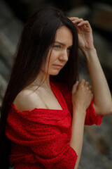 Fototapeta premium Dark-haired girl with long hair in a red dress close-up portrait