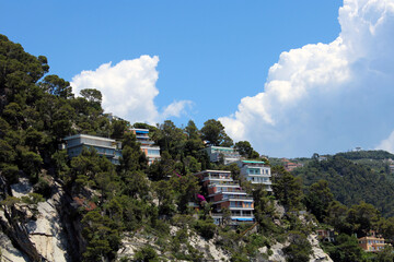Fototapeta na wymiar Case assolate sulla roccia tra Rapallo e Zoagli con cielo e nubi