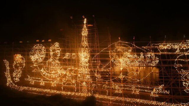 Traditional fire boat floating in Mekong river at night in Nakhon Phanom, Thailand