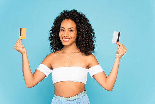 Cheerful African American Woman Holding Credit Cards Isolated On Blue