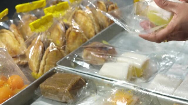 A street food vendor in Thailand cuts a popular jelly dessert and wraps it in plastic