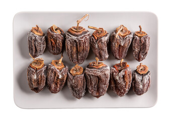 Dried persimmon on gray plate isolated on white. Top view.