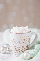 Mug with hot chocolate and marshmallow, sweater. Cozy christmas composition. Hygge concept Soft focus