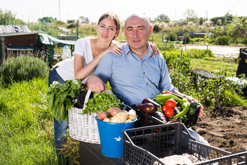 Joyful couple with a basket of vegetables in the garden. High quality photo