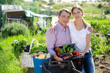 Happy couple with harvest of vegetables in the garden. High quality photo