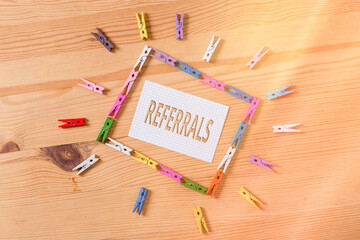 Writing note showing Referrals. Business concept for act, action, or an instance of referring to...