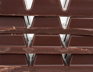 stack of pieces of black chocolate on a white background