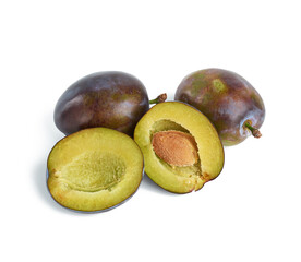 ripe whole blue plum, broken in half with a bone