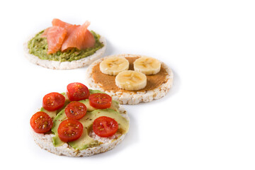 Assortment of ingredients on puffed rice cakes isolated on white background. Copy space	