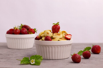 Small pancakes with strawberries, quick healthy breakfast, pancake porridge on a gray background