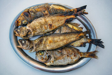Fresh sea fish on metal plate roasted on ember, ready to eat, mediterranean Croatia