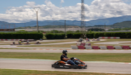 black and silver helmet driver driving a kart on a circuit