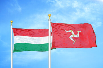 Hungary and Isle of Mann two flags on flagpoles and blue cloudy sky