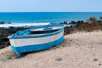 Fototapeta na wymiar Blue boat abandoned on the beach