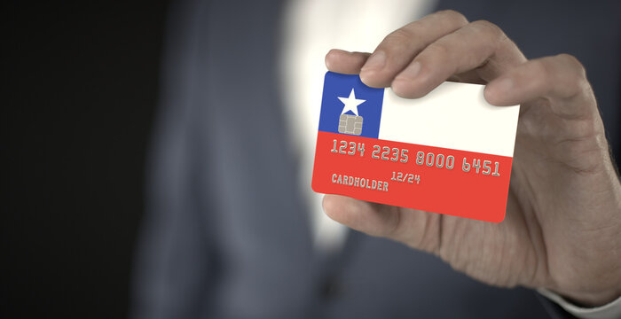 Businessman holding plastic bank card with printed flag of Chile, fictional numbers