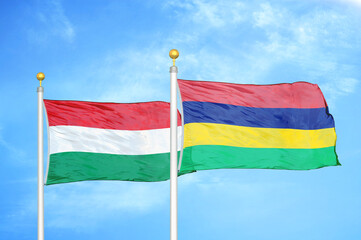 Hungary and Mauritius two flags on flagpoles and blue cloudy sky