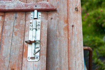 Metal lock on a wooden water well in the garden. Old brown well.