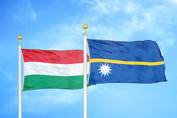 Hungary and Nauru two flags on flagpoles and blue cloudy sky