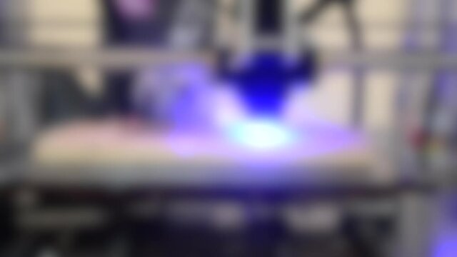 Blurred background. Laser engraving on wood. 3D printer laser beam burns