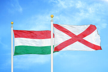 Hungary and Northern Ireland two flags on flagpoles and blue cloudy sky