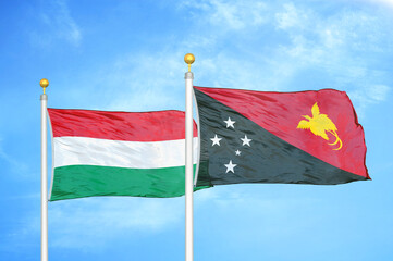 Hungary and Papua New Guinea two flags on flagpoles and blue cloudy sky