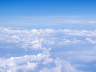 Fototapeta premium Aerial view of cloudscape seen through airplane window