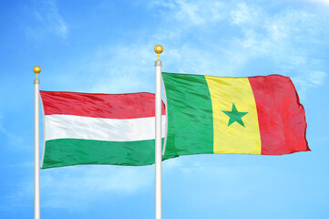 Hungary and Senegal two flags on flagpoles and blue cloudy sky