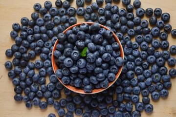 Fresh blueberry in wooden bowl and on the wooden board. Top view Texture blueberries background close up with copy space for text.  Concept of healthy and dieting eating.  Summer healthy food. Banner.