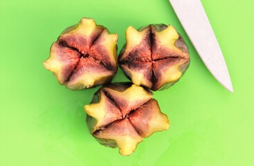 Three ripe green figs cut open with knife