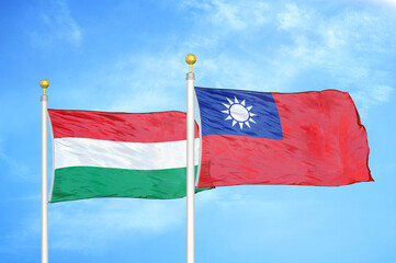 Fototapeta na wymiar Hungary and Taiwan two flags on flagpoles and blue cloudy sky