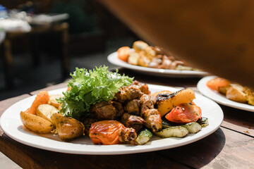 Decoration of a plate with shish kebab with greens
