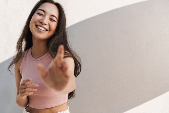 Image Of Joyful Asian Beautiful Girl Reaching Out At Camera