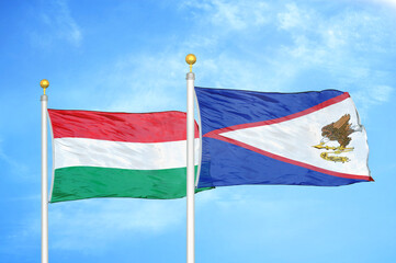 Hungary and American Samoa two flags on flagpoles and blue cloudy sky