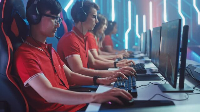 Diverse Esport Team of Pro Gamers Play in Mock-up FPS Shooter Video Game on a Championship. Stylish Neon Cyber Games Arena. Online Broadcasting of Tournament Event. Side View Dolly