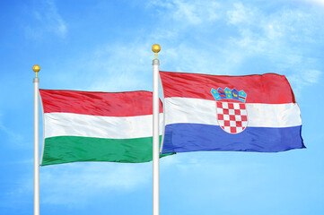 Hungary and Croatia two flags on flagpoles and blue cloudy sky