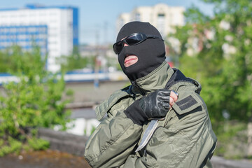 A bandit in a mask and black glasses rests and looks at the sun 